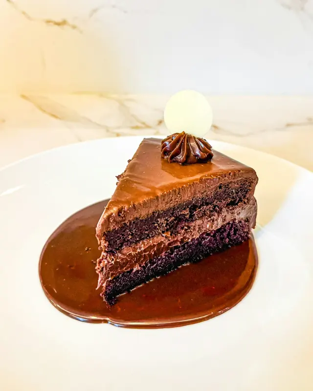 Fatia de bolo de chocolate com cobertura cremosa